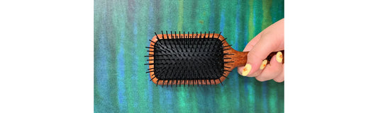 person holding different types of hair brushes